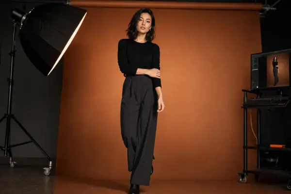 Editorial photography 2 High-end editorial photoshoot at PM STUDIOS Munich: Full-body shot of a model in black attire against a warm terracotta backdrop, featuring professional softbox lighting and tethered capture workstation.