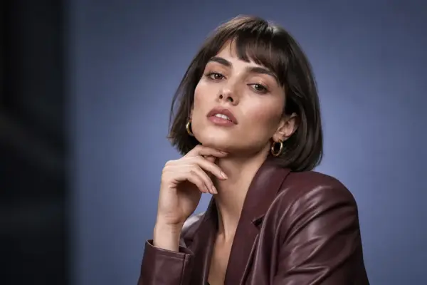 Beauty & Fashion Photos 5 Professional beauty portrait by PM STUDIOS Munich: A stylish woman with a dark bob haircut and burgundy leather jacket posing against a sophisticated grey-blue studio background.